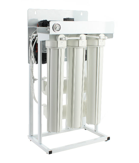 A white, three-canister reverse osmosis system on a white metal stand is seen in this image. The Premiere Sales 600 GPD Light Commercial RO System Floor Standing Reverse Osmosis includes attached tubing and a pressure gauge, featuring advanced TFC reverse osmosis membranes.